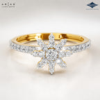 A gold and white gold ring featuring a central snowflake-like cluster of round brilliant-cut diamonds, with a pavé-set diamond band, shown on a clean white background. ARIA DUTTA branding is visible in the top left, and Sparkles jewelry branding is in the top right.
